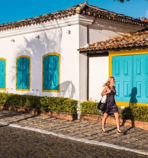 一名女子走在一栋蓝色大门的房子前