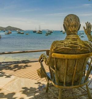 一个人坐在椅子上望着水的雕像