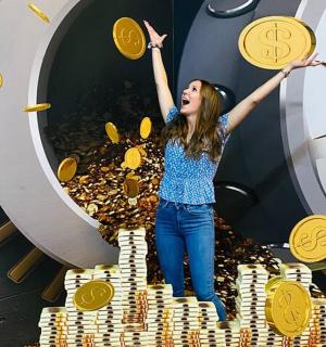 a woman is standing on a pile of gold coins