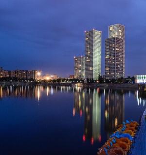 a city skyline at night with a body of water