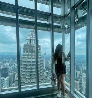 a woman standing in a window looking at a city