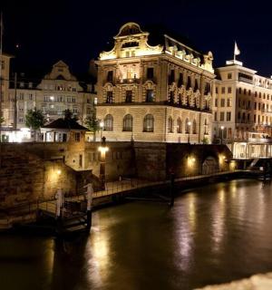 ein beleuchtetes Gebäude neben einem Fluss in der Nacht