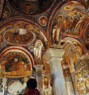 a person standing in front of a wall with mosaics