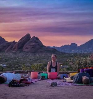 a woman sitting in front of a group of people laying on the ground