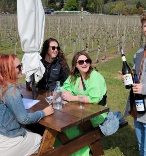 一群人围坐在桌旁,桌上摆满了酒瓶