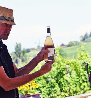 一个戴着帽子的男人拿着一瓶酒