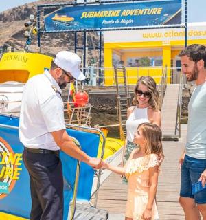 una família donant-se la mà en un moll al costat d'un vaixell