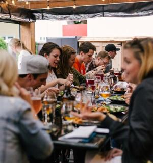 a group of people sitting at a table eating food