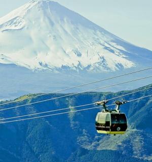 two cable cars flying in front of a mountain