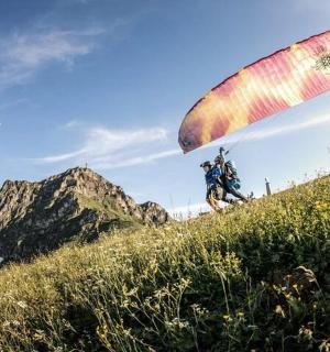 inimene, kes langevarjuga mäe otsas lendab
