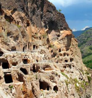 a rocky mountain with dwellings on the side of it