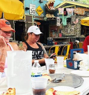 a group of people sitting at a table eating pizza