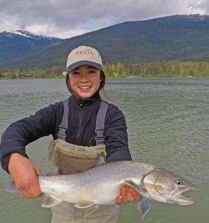 一个小女孩在湖里抱着一条鱼