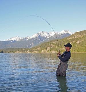 一名男子站在湖水中钓鱼