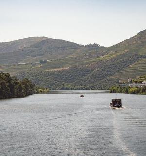 a boat on a river with hills in the background