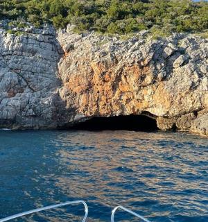 a boat in front of a cave in the water