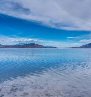 a large body of water with mountains in the background