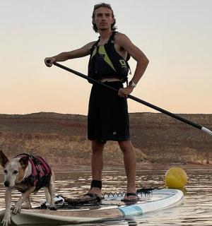 muž a pes na paddleboardu