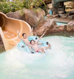 two people riding a water slide in a pool