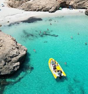 a yellow boat in the water at a beach