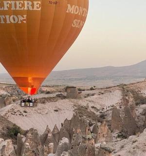 a hot air balloon flying over a rocky landscape