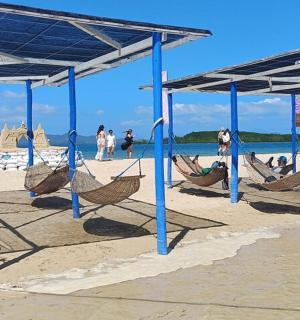a beach with blue poles and hammocks on the sand
