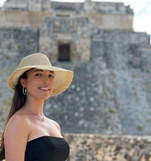 a woman wearing a hat standing in front of a castle