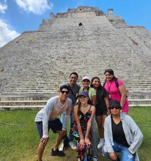 a group of people posing in front of a pyramid