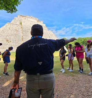 a group of people standing around a pyramid