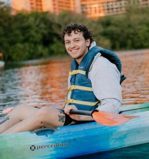 muž sedící v lodi ve vodě