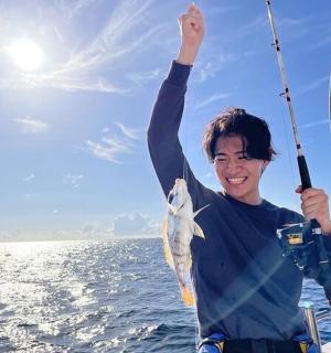 a man holding a fish in his hand on a boat