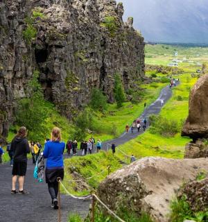 a group of people walking on a path between rocks