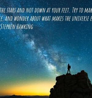 a man standing on top of a mountain under a night sky