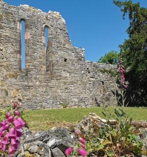 一座有两扇窗户和鲜花的古老石头建筑