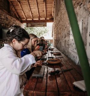 skupina lidí stojící kolem dřevěného stolu