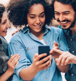 a group of people looking at a cell phone
