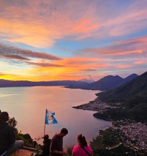 一群人坐在山顶上看湖