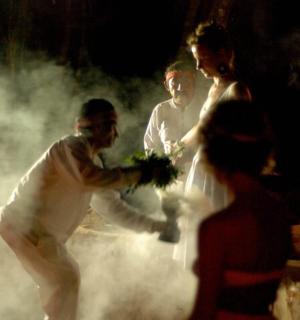 a bride and groom dancing in a cloud of smoke