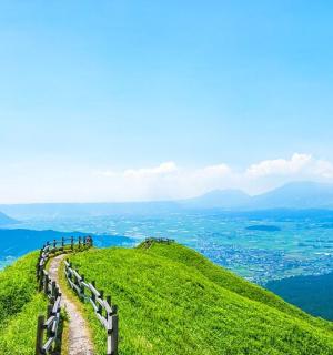 en vej på toppen af en grøn bakke