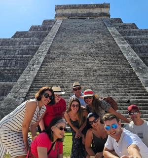a group of people posing in front of a pyramid