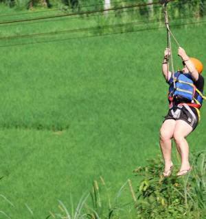 คนกำลังห้อยตัวอยู่บนเชือกบนซิปไลน์