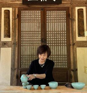 a woman sitting at a table with blue bowls