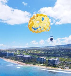 a yellow parachute is flying over a beach