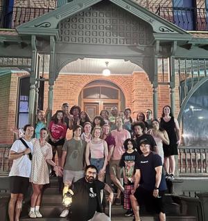 a group of people posing in front of a house