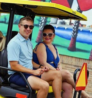 muž a žena sedící v golfovém vozíku