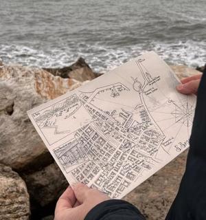 osoba držící kresbu oceánu