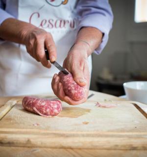 osoba krojąca kawałek mięsa na desce do krojenia