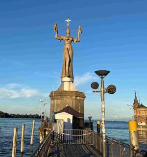 a statue of a woman standing on a pier