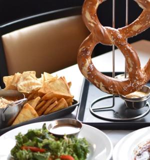 stůl s talíři jídla, preclíkem a hranolky