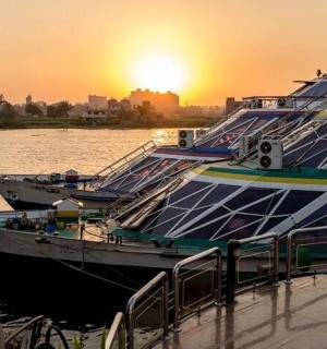 两艘船停靠在码头，背景是日落